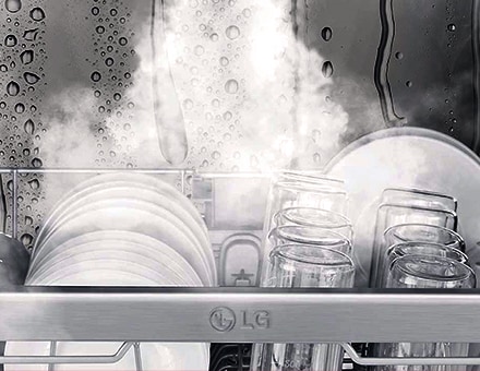 LG dishwasher interior with steam cleaning plates and glasses, visible water droplets and steam inside.